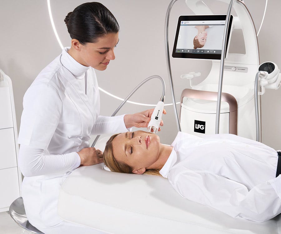 Esteticista realizando un tratamiento estético endermologie® en la parte inferior del cuerpo de una paciente